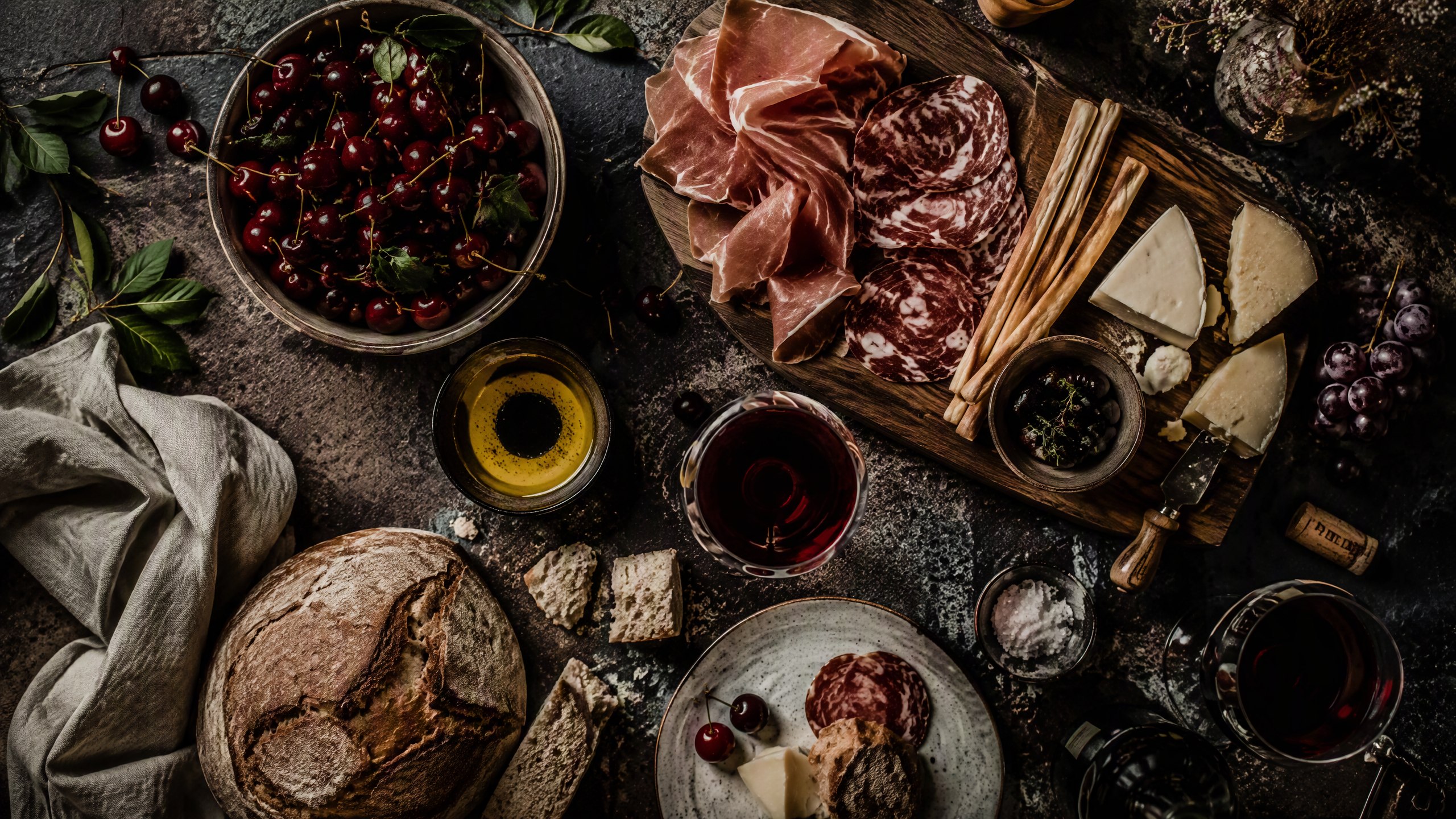 Overhead Brda feast table with cherries, bread, olive oil and wine