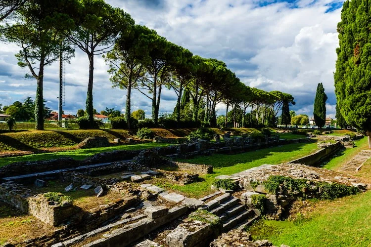 Panoramic view of the Aquileia archaeological area with ancient ruins and Mediterranean pine trees