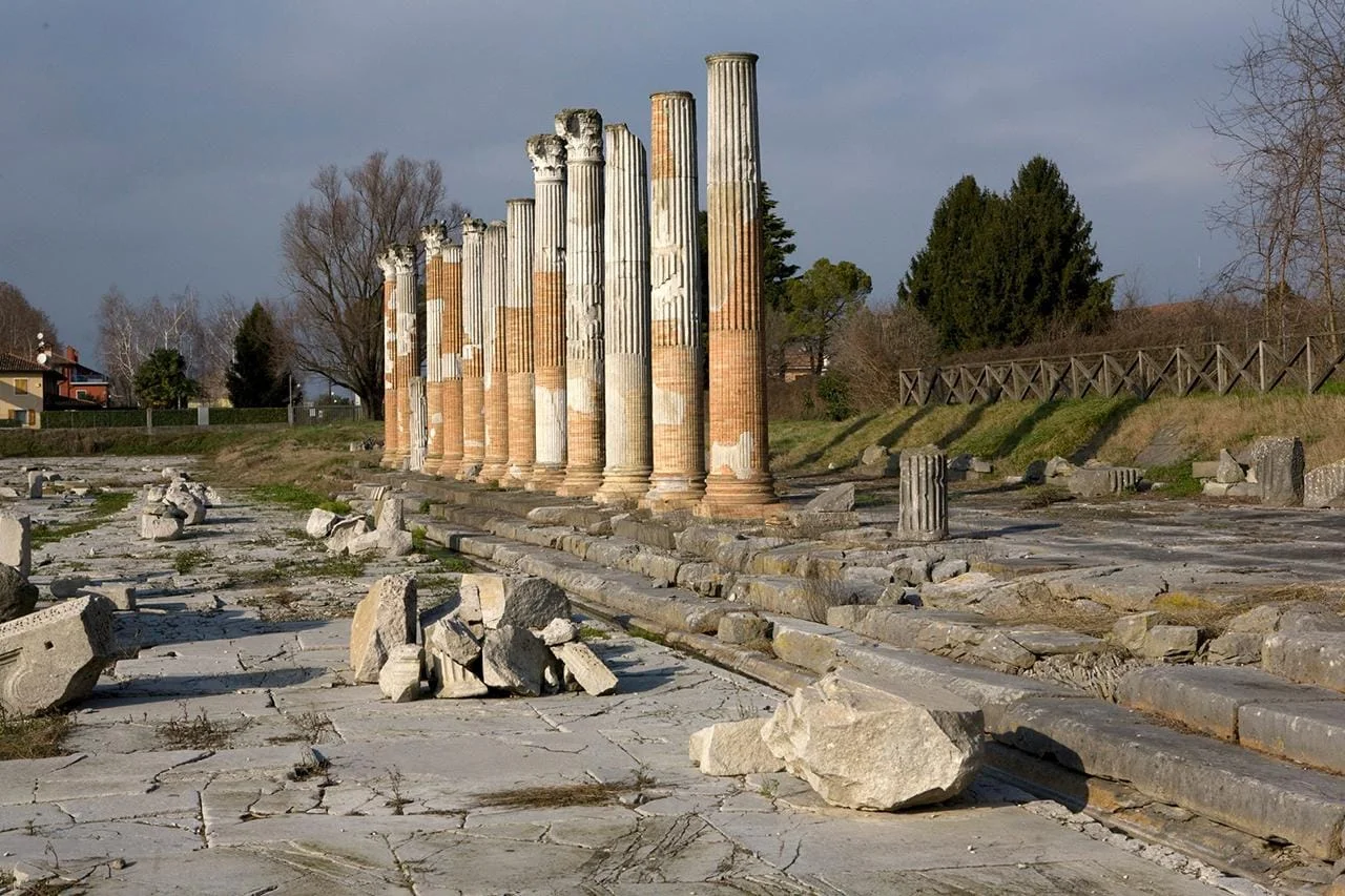 The Roman forum of Aquileia with its impressive colonnade and the medieval bell tower of the Basilica in the background