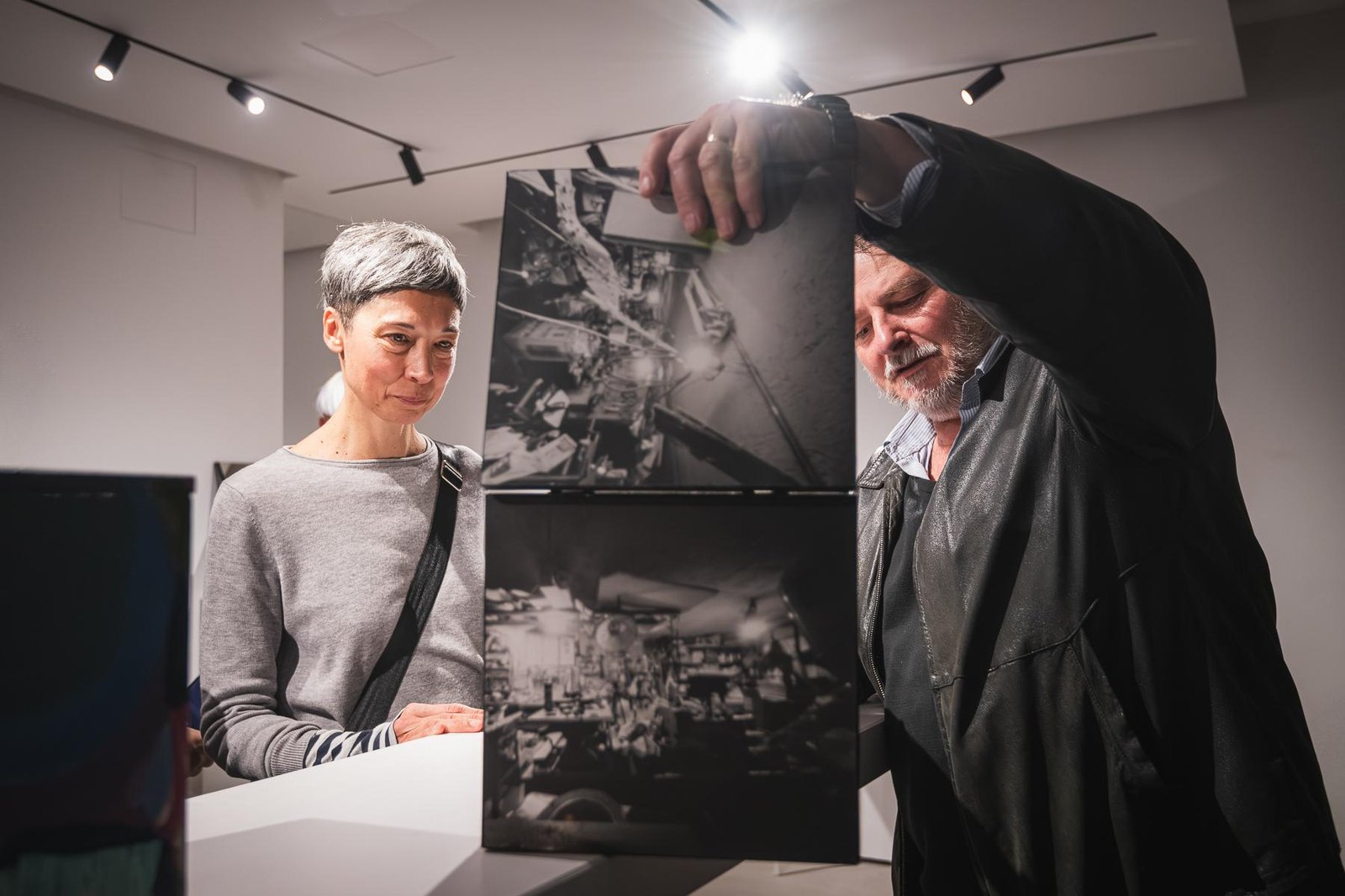 Visitors examining photographic prints inside Gallery GONG