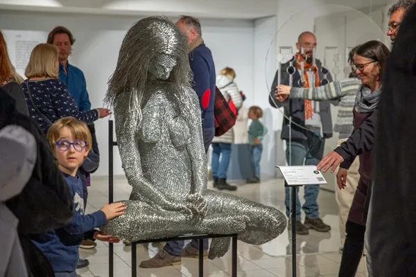 Visitors interacting with contemporary tactile sculpture